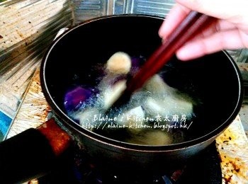 step4: 煲內加入油 , 先放入茄子拌勻 , 用慢火慢慢炸至微黃色