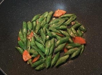 step3: 先下扁豆並加黑胡椒粉和適量的鹽拌炒到扁豆變深色。