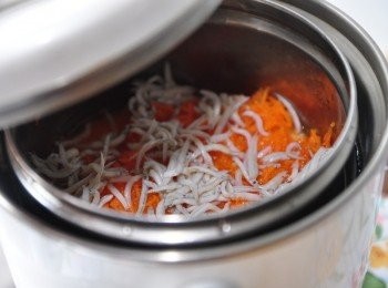 step8: 也同時將沖洗過的吻仔魚鋪上，外鍋放1米量杯水啟動電源燉煮