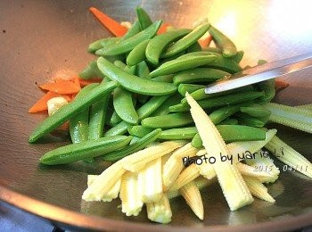step3: 起鍋，開中大火
倒入少許沙拉油於鍋中
蒜瓣先下鍋拌炒一下
依序放入紅蘿蔔、甜豆和玉米筍
將<span class="group_1">食材</span>均勻拌開後調入適量的鹽巴
倒進少許溫開水稍悶一下即可。