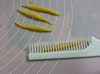 step10: 將1份8g粟米粒的麵團再分成4份,搓成銀針粉形狀,用一把乾淨的梳上下推動推出粟米粒狀(如梳的齒太密可隔一條剪斷)