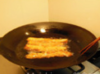 step9: 油鍋放在中火上，待油燒至六成熟後，加入五香生坯炸至表面金黃，整條下鍋炸，待五香卷浮出油面後，用筷子翻面炸勻，至金黃色後，撈出瀝油，切片即食