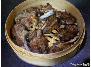step6: 接著再將巳烘烤完成的羊小排均勻的擺放在竹籠內，放入深鍋內 再蓋上鍋蓋開中小火的方式，進行煙燻（煙燻的時間大約是10~15分鐘左右） 入鍋煙燻時，大約每５分鐘左右要將羊小排適時的翻面