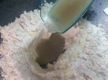 step8: 將麵粉開窩後,將所有材料加入窩中,再慢慢加入酵母水搓成柔滑麵糰