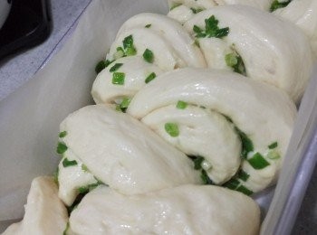 step3: 將<span class="group_2">配料</span>混合，造成香葱醬。取出麵糰排氣，再擀平成長方型，搽上香葱醬。將麵糰平均切成8份，但不要切斷麵糰底部；然後左右梅花間竹擺放(類近麥穗做法)並翻出，放入模具或烤盤再發酵至2倍大。