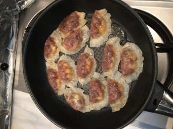 step3: 焗爐 200度預熱10分鐘。

下點油，下餃子煎約5分鐘。然後下約半杯水到鍋，蓋鍋蒸煎多5分鐘。

準備焗盤，在盤下舖上肉醬。然後把煎好的餃子放到焗盤上，然後豪邁的灑下芝士碎。放進焗爐約10分鐘到餃子皮微焦