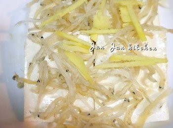 step1: 豆腐切件，排上碟。銀魚乾用暖水浸10分鐘，沖淨瀝乾，放於豆腐上，加上薑絲及紅椒粒，喜歡還可加上豆豉，水滾隔水中火蒸10分鐘。