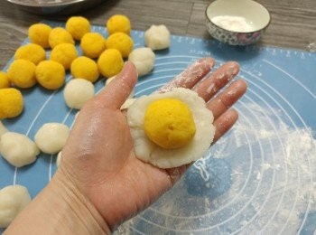 step16: 將冰皮粒按成圓形薄片; 放上奶黃餡粒,