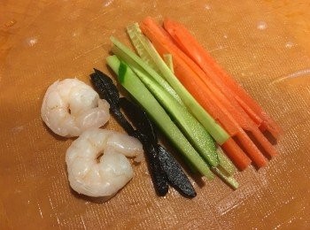 step3: 3 把青瓜絲，蘿蔔絲，黑蒜和蝦放上米紙中間，輕手把四邊包好