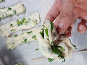 step16: 再將竹籤部位的粉糰摺向尾部,抽出竹籤,按實頭尾,放上牛油紙上