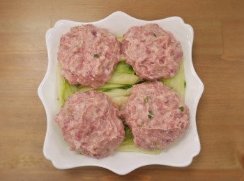 step3: 步驟3：
取蒸盤鋪上芽白心擺上肉丸入蒸鍋蒸25分，另用高湯汆燙洗淨的青江菜備用。