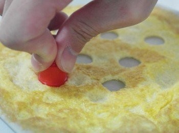 step5: 接著將兩顆雞蛋其中一顆雞蛋的蛋白另外取出後各自拌勻!!會有兩碗蛋液(一碗是基本蛋液,另一碗是蛋白液)一定要徹底拌勻喔!!在平底鍋中抹油均勻擦開後倒入基本蛋液煎熟後取出~取一小圓形容器在蛋皮上壓出洞來!!!