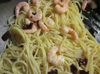 step5: 義大利麵撈起加入作法4.鍋中拌炒,拌炒中太乾則加入一些煮麵水,因為煮麵水本身有鹹味,所以調味時要視情況添加塩巴,拌到均勻後起鍋盛盤,灑上作法3的金黃蒜片即可上桌