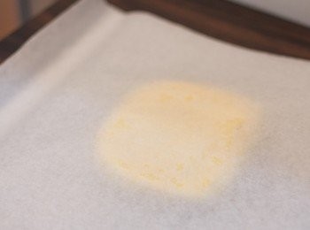 step7: <span class="group_1">撻皮</span>枱面鋪一張烘焙紙，於冰箱取出已冰凍的粉團放於烘焙紙上面．粉團面再放上另一張烘焙紙