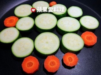 step3: 取出平底鍋，放入櫛瓜片和紅蘿蔔片，開中火乾煎（不加油）。