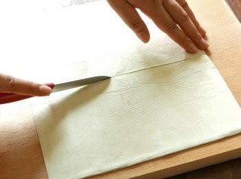 step5: 按包裝指示把即用酥皮解凍，把酥皮平均切成2份後，把酥皮疊起。
（如酥皮表面較濕或天氣較潮濕，可在工作面上灑上一層薄薄的麵粉再操作，防止酥皮黏著工作面）
（如有在工作面上灑麵粉，要注意把皮疊起時應該把2張酥皮沒有沾到麵粉的一面貼在一起）