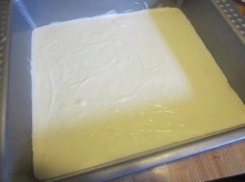 step2: 称量好各种用料2材料,奶油奶酪+黄油软化，+糖搅拌均匀。天气冷的话，可以坐热水搅拌,加入鸡蛋，继续搅拌,加入牛奶和香草精，搅拌均匀.倒入垫了饼皮的模具