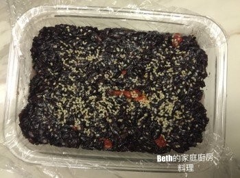step6: 最後舀上紫米糕，灑上一些白芝麻，蓋上保鮮膜，用湯匙壓平