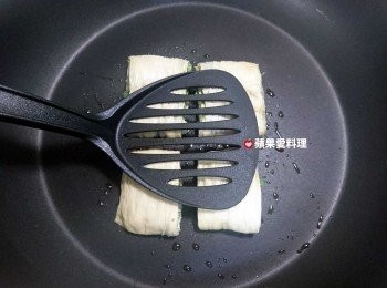 step10: 以鍋鏟輕壓豆皮上頭，使豆皮捲更密合。