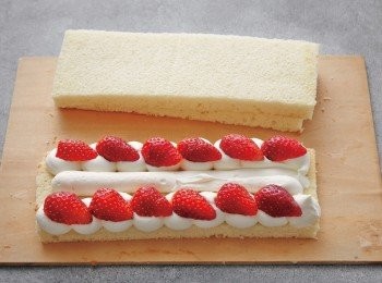 step6: 將5的發泡鮮奶油填入裝有粗口徑的圓形擠花嘴（大約1.2cm）的擠花袋中。取4的海綿蛋糕1片，擠上發泡鮮奶油之後，放上草莓