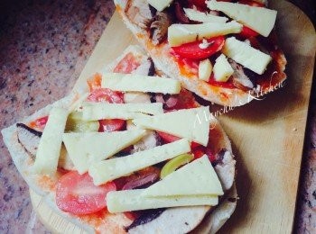 step2: 大蘑菇抹淨切片，車厘茄對切和莎樂美腸平均放在麵包上。鋪上已對切的橄欖，並澆上浸橄欖的油或汁液。芝士鋪面，180度焗約10分鐘至芝士融化、麵包脆身。