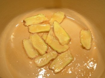 step2: 鍋中倒入黑麻油，放入薑片以小火爆至香薑片邊緣呈現微焦黃。