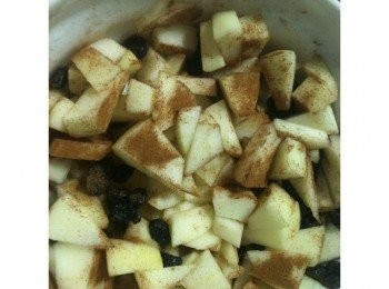 step4: 準備內餡：取出一個碗，放入切小塊蘋果，放進葡萄乾，灑上肉桂粉，用湯匙攪拌均勻。