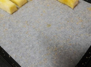 step5: 烤盤舖上烘焙紙 , 灑上黃砂糖 , 把浸泡好奶油的麵包條放上