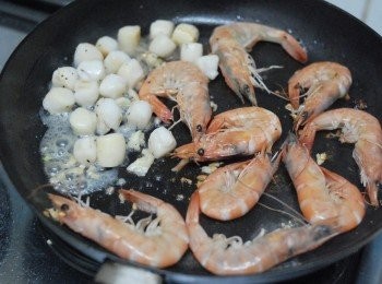 step1: 熱鑊下油，先煎蝦及帶子，下鹽及黑胡椒粉調味，盛起備用