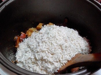 step3: 倒入米和所有的调味料反抄搅拌均匀，再倒入水，关锅盖，（ Milestone多功能营养锅 ）按入“Rice”煮饭，直到闪灯为之，开盖倒入“油葱酥”搅拌圴匀,即可享用～