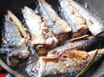 step2: 先放入薑片爆香，再將秋刀魚平鋪香煎，要不定時的翻面，讓兩面都煎的香酥