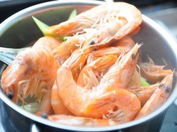 step2: 先以少許米酒、水、薑片、蒜片滾煮，放入白蝦煮熟撈起放涼備用