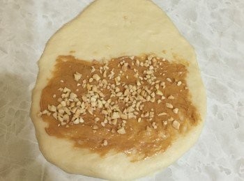 step4: 麵團用木棍壓開，塗上花生醬和加入花生粒，捲起。