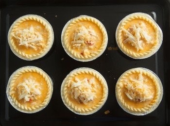 step5: 將步驟3的材料均勻的填入烤好的塔皮中並灑上適量的起司絲後，放入預熱好190度的烤箱中烘烤約15~20分鐘。