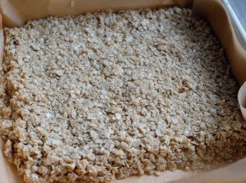 step3: 然後倒入鋪有烘焙紙的焗盤上，壓實，放入已預熱180度焗爐，焗約25-30分鐘