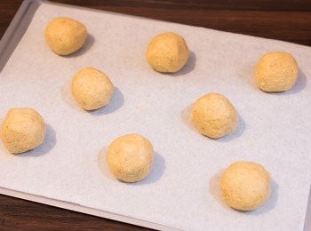 step8: 組合方法：焗爐預熱至攝氏 190 度。曲奇粉團分成 14 份（每份約 30 克），搓成圓球狀，置於已鋪上牛油紙的焗盤上。