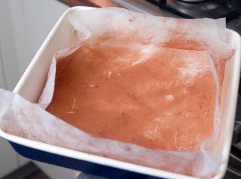 step2: 用烘焙紙鋪在9x9吋（24x24cm）的烤盤內，然後塗一層牛油，再灑上中筋麵粉（我改用了可可粉）將多餘的粉倒出