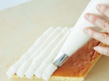 step13: 在鮮奶油裡加入細砂糖打至8分發泡，製作成發泡鮮奶油。填入擠花袋（單邊呈鋸齒狀的擠花嘴）裡，依序擠出一條條發泡鮮奶油。