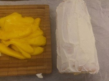 step11: 先將忌廉塗在蛋糕面,再鋪上芒果片,之後用牛油紙卷好。