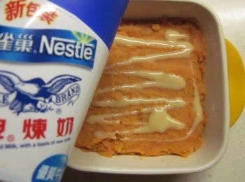 step2: 地瓜削皮切片外鍋以0.7杯水放電鍋蒸熟,地瓜趁熱壓成泥,加入奶油及煉乳1大匙拌勻(可視個人口味增減煉乳及奶油份量),填入烤盤再擠上煉乳1大匙