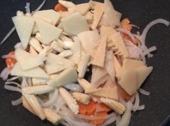 step6: 接著放入洋蔥拌炒，再放入紅蘿蔔片及小玉米拌炒，再加入筍片。