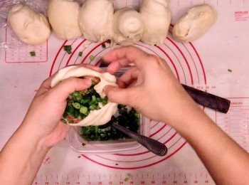 step12: 發好麵糰卷口向上按扁，再在四周捍薄（中間要比四周厚點），之後將麵糰放上手，先放上豬肉，再放蔥粒，邊推餡入內邊摺包好 （摺不摺隨意）