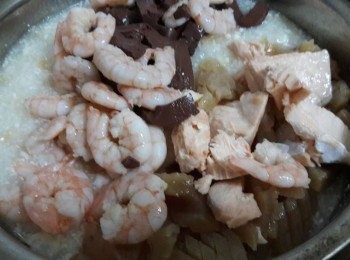 step7: 電鍋跳起後 , 加入已預先汆燙過的蝦子 , 鮭魚和魷魚 , 外鍋再加入二杯水 , 按開關