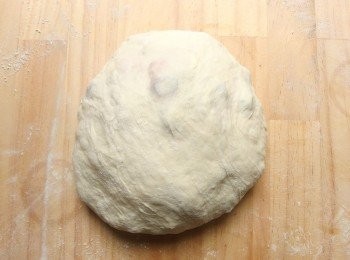 step6: 在工作檯面上灑上高筋麵粉可避免麵糰沾黏。將麵糰用刮板取出放在灑有高筋麵粉的檯面上,在麵糰表面上也灑上少許的高筋麵粉將空氣拍出(輕柔拍出~),將麵糰用雙手滾圓成型。