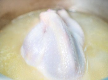 step2: 把少許鹽掃上雞的表面及雞肚內，然後把薯仔和全雞加入雞湯中，燒滾後轉小火煲20分鐘。