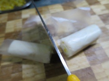 step7: 用刀連同牛油紙將酥皮卷一起切開兩件