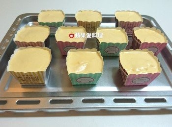 step7: 烤箱180℃預熱10分鐘。預熱烤箱時，開始裝模。杯子蛋糕模排在烤盤上，將麵糊倒入模中至9分滿，倒完後拿起烤盤輕敲兩下（使麵糊中的空氣排出），放進烤箱以180℃烤25分鐘。
