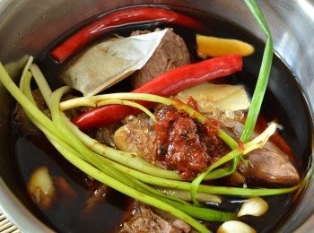 step2: 把汆燙過的牛腱、薑片、蒜頭、辣椒、蔥、滷包與 調味料放於內鍋。