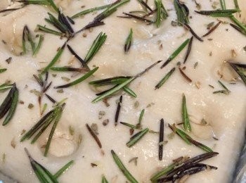 step9: 烤箱預熱180度。取出麵團，倒去多餘水分，麵團上面撒些許高粉，擢小孔（深一點點更好，因為遇熱膨脹，太淺的孔孔會沒了），然後掃上米糠油，迷迭香及香草碎平均鋪面，