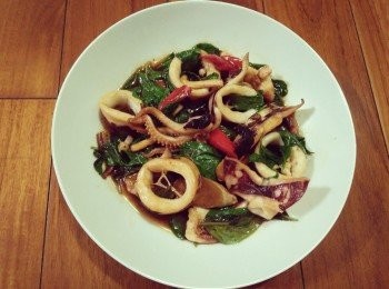 step2: 熱鍋後，放入1匙麻油，接著放入薑片爆香， 約略1分鐘，等薑片香氣出來，開中小火， 依序放入澎湖小管【澎湖野生水產】、辣椒、黑蒜頭【富陽生技】、少許米酒、醬油、塩，並炒勻，約略7-10分鐘，